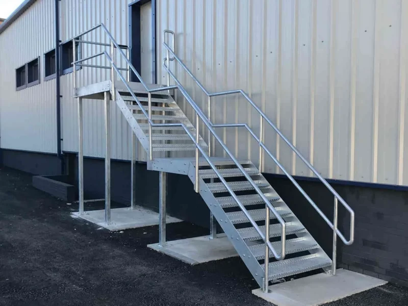 Galvanised external fire escape staircase fixed to white profile cladding