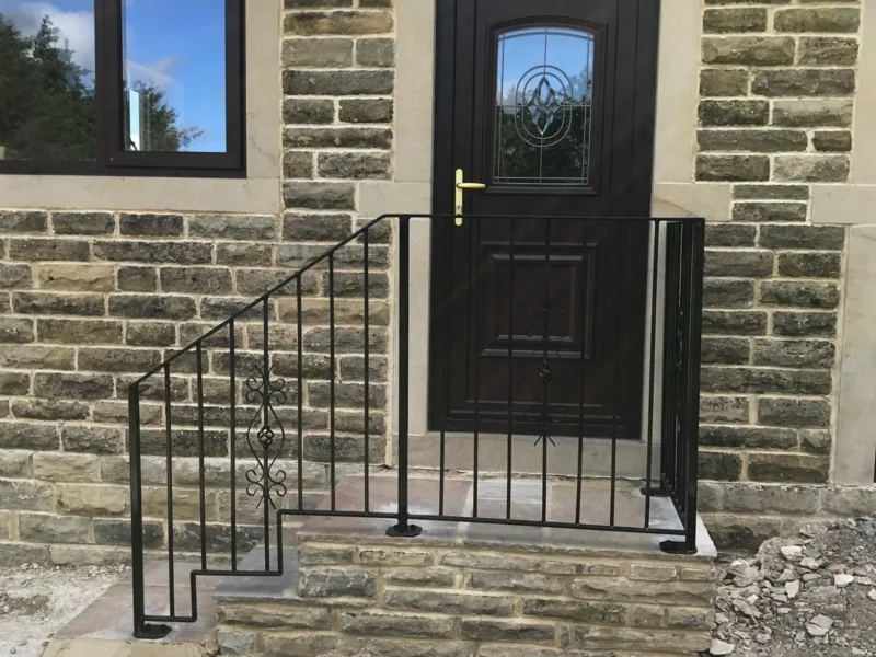 Black steel handrail to stone entrance steps