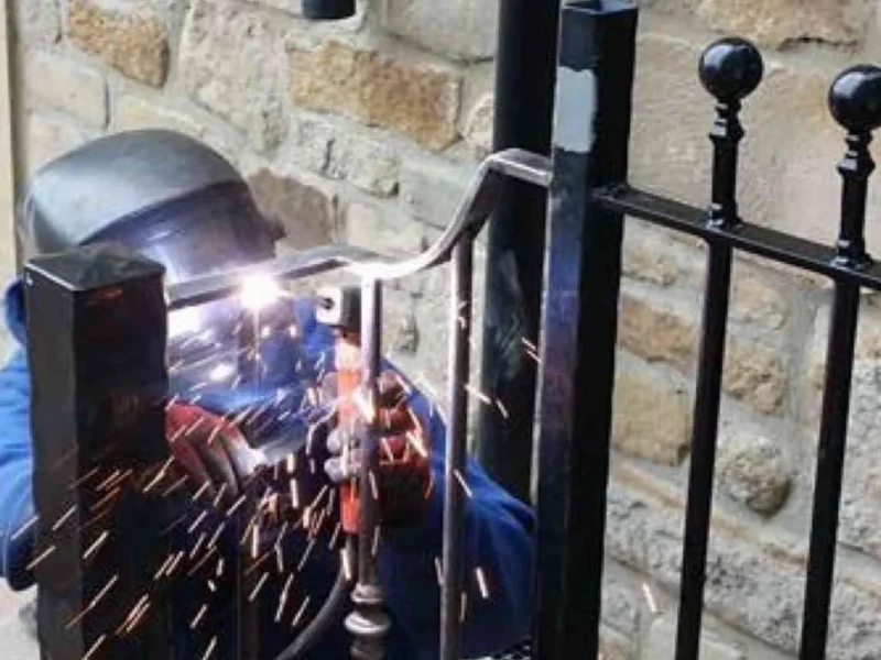 J R Fabrications welder finishing a steel railing with ball finials