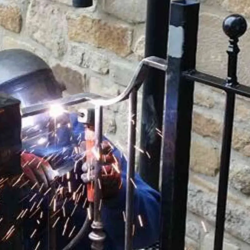 J R Fabrications welder finishing a steel railing with ball finials